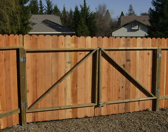 A wooden fence featuring a gate, showcasing the natural texture and design of wood fencing in a serene outdoor setting.