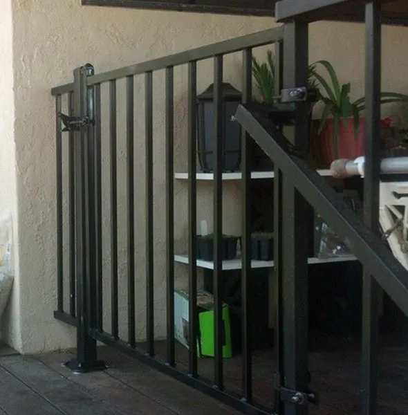 A decorative black wrought iron fence lines the edge of a wooden deck, adding elegance and safety to the outdoor space.