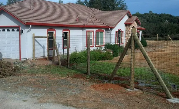 A wooden railing positioned beside a house, serving as a decorative element and functional boundary akin to fences.