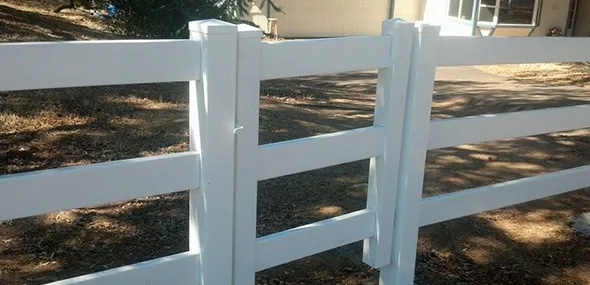A white vinyl fence featuring a gate, providing a clean and modern boundary for a property.